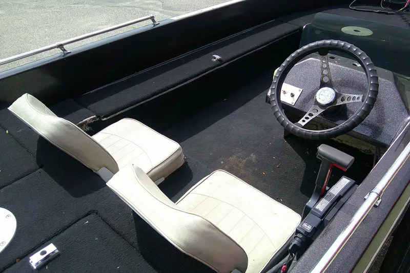 Slide: The Image of 1981 Ranger 1600 V-III boat interior with steering wheel and two white seats. - 6