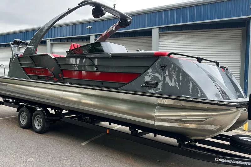 The Image of 2025 Trifecta Sport RF9 DC pontoon boat on trailer, sleek design, gray and red accents. - 1