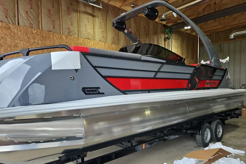 Slide: The Image of 2025 Trifecta Sport RF9 DC pontoon boat in a garage, featuring sleek design and modern features. - 3