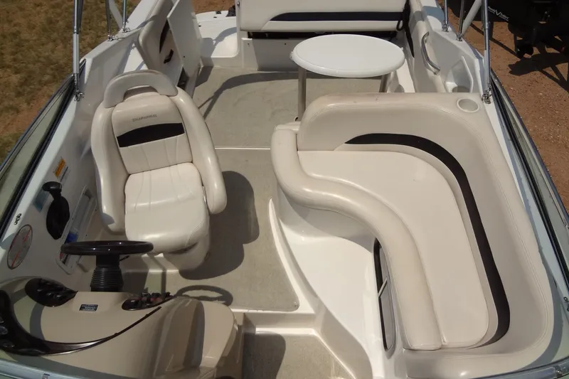 Slide: The Image of 2000 Chaparral Signature 260 boat interior with white seating and steering wheel. - 10