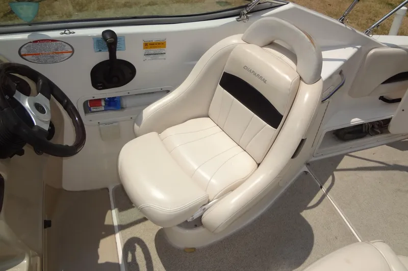 Slide: The Image of 2000 Chaparral Signature 260 boat interior with steering wheel and white captain's chair. - 11