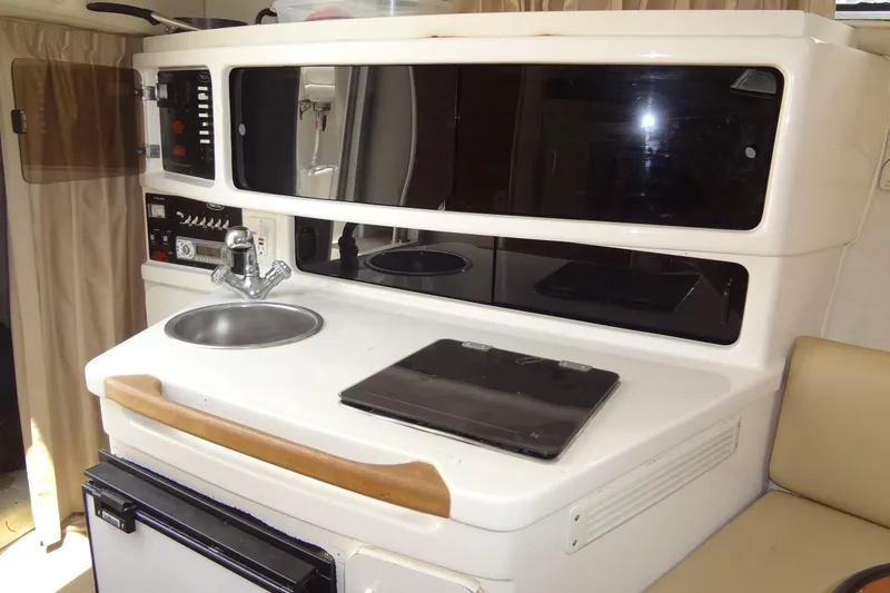 Slide: The Image of 2000 Chaparral Signature 260 boat interior with kitchenette, sink, and storage cabinets. - 22