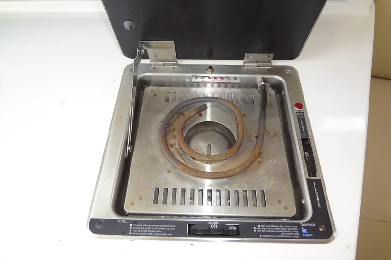 Slide: The Image of Electric stove in 2000 Chaparral Signature 260 boat galley, featuring a single coil burner. - 24