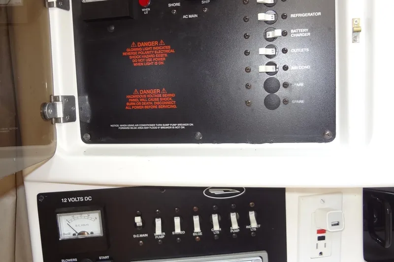 Slide: The Image of Electrical control panel on a 2000 Chaparral Signature 260 boat, featuring switches and warnings. - 26