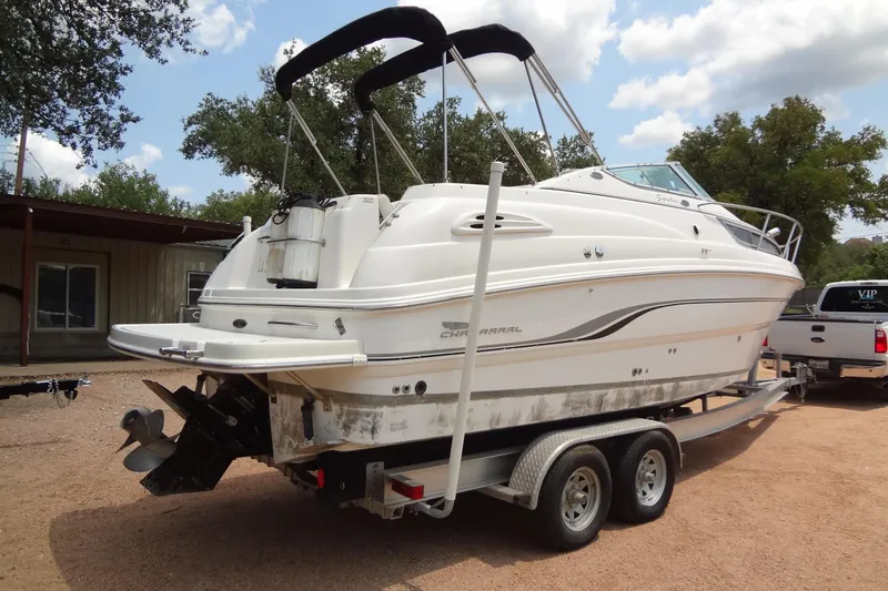Slide: The Image of 2000 Chaparral Signature 260 boat on trailer, parked outdoors under a partly cloudy sky. - 5