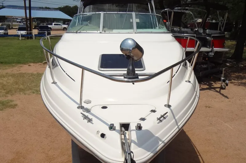 Slide: The Image of 2000 Chaparral Signature 260 boat, front view, parked on land, showcasing sleek design. - 8