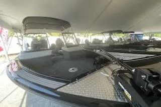 Slide: The Image of 2026 Smoker Craft 210 GLS Sport boat under a canopy, showcasing sleek design and seating. - 6