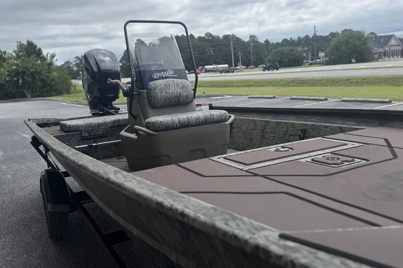 Slide: The Image of 2026 Tracker Grizzly 1860 CC boat on trailer, featuring camouflage seating and powerful outboard motor. - 4