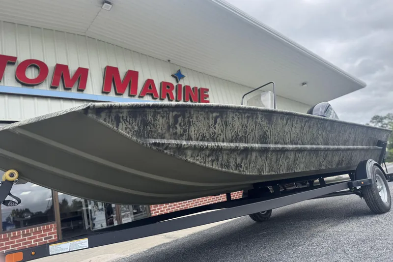 Slide: The Image of 2026 Tracker Grizzly 1860 CC boat on trailer outside marine store. - 5