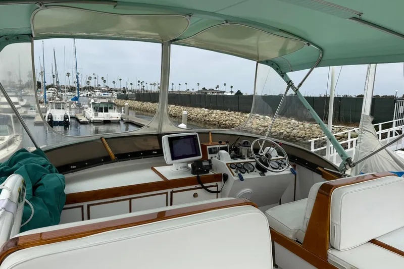 Slide: The Image of 1979 Pacific Bluefin Sportfisher boat interior with steering wheel and navigation equipment at marina. - 19