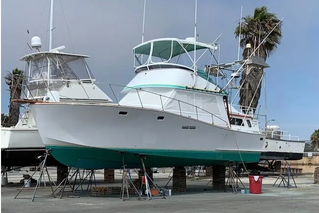 Slide: The Image of 1979 Pacific Bluefin Sportfisher boat on dry dock, with palm trees in the background. - 2