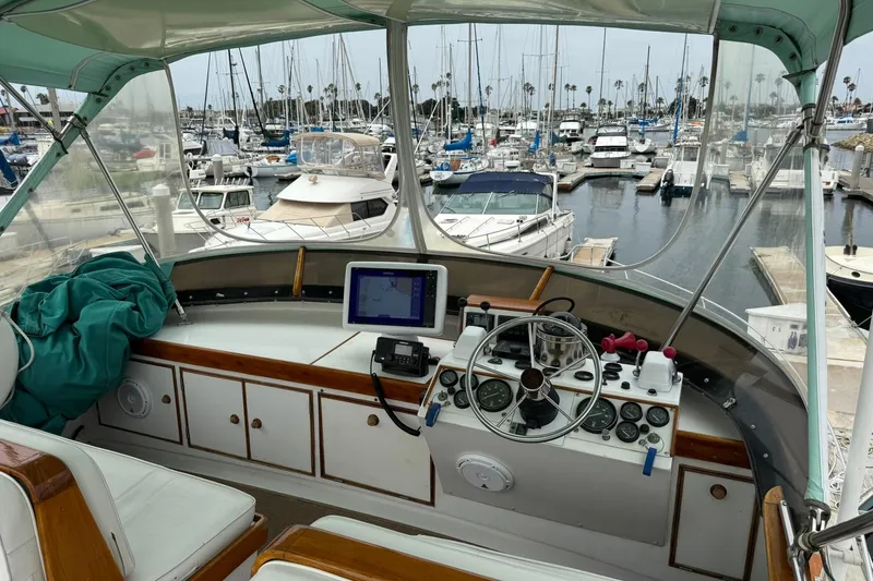 Slide: The Image of 1979 Pacific Bluefin Sportfisher boat cockpit with marina view, featuring navigation equipment and controls. - 20