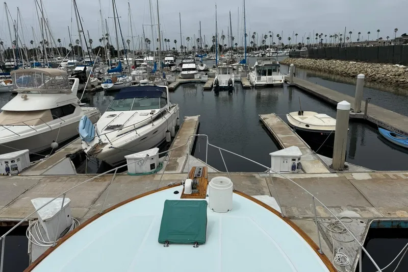 Slide: The Image of 1979 Pacific Bluefin Sportfisher docked in a marina with surrounding boats and calm waters. - 22