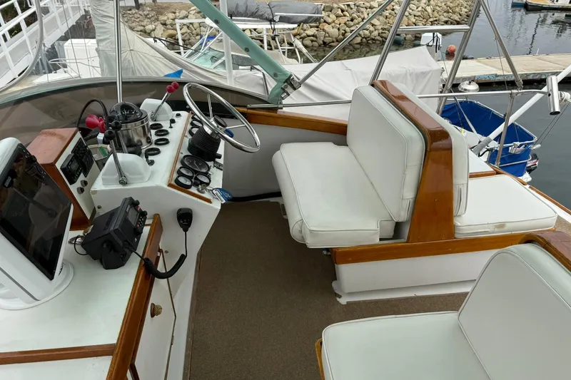 Slide: The Image of 1979 Pacific Bluefin Sportfisher boat cockpit with steering wheel, controls, and white seating. - 23