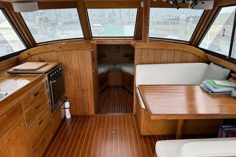 Slide: The Image of Interior of a 1979 Pacific Bluefin Sportfisher boat with wood paneling and seating area. - 4