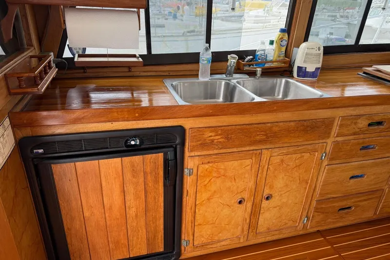 Slide: The Image of 1979 Pacific Bluefin Sportfisher kitchen with wooden cabinets and dual sink. - 8