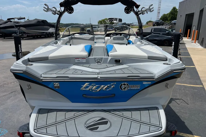 Slide: The Image of 2016 Tigé Z1 boat with blue and white design, parked at a marina. - 4
