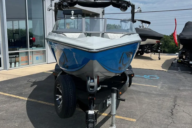 Slide: The Image of 2016 Tigé Z1 boat in blue, parked on a trailer outside a showroom. - 7