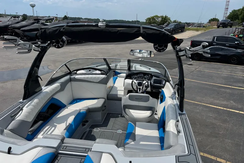 Slide: The Image of 2016 Tigé Z1 boat interior with blue and white seating, parked in a lot. - 8
