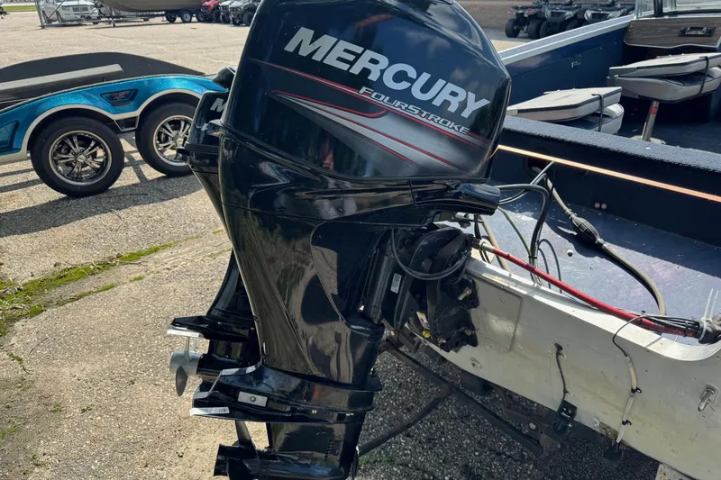 Slide: The Image of 2015 Mercury 60ELPT outboard motor attached to a boat, parked on a trailer. - 1