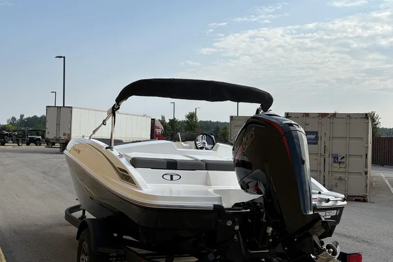 Slide: The Image of 2026 Tahoe TAHT18 boat with outboard motor, parked on a trailer in an industrial area. - 4
