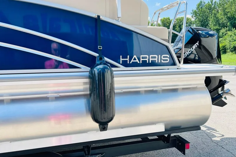 Slide: The Image of 2026 Harris Cruiser Sunliner 250 CW boat with Mercury engine, docked outdoors. - 10