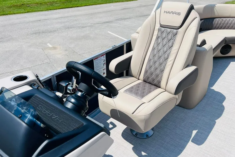 Slide: The Image of 2026 Harris Cruiser Sunliner 250 CW boat interior with luxurious captain's chair and steering console. - 17