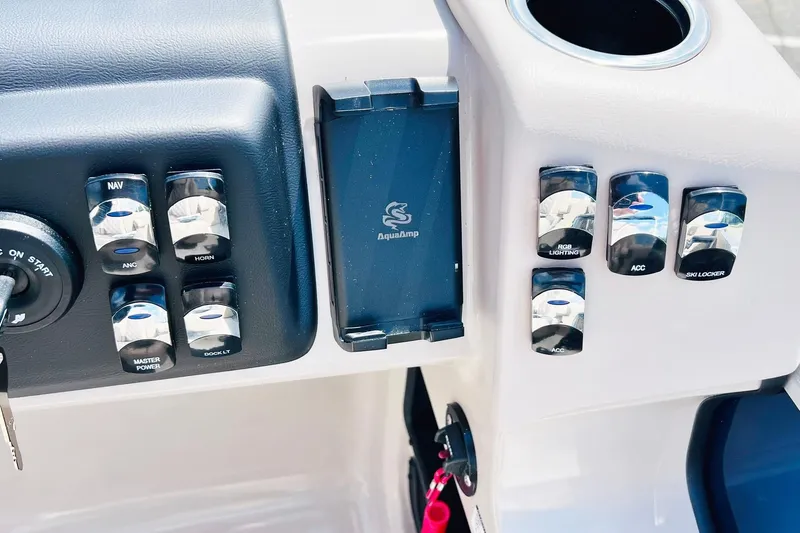Slide: The Image of Control panel of 2026 Harris Cruiser Sunliner 250 CW boat with various switches and key ignition. - 25