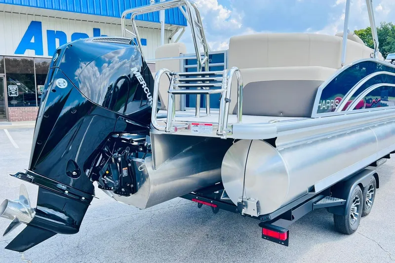 Slide: The Image of 2026 Harris Cruiser Sunliner 250 CW boat with 200HP Mercury engine, parked outdoors. - 38