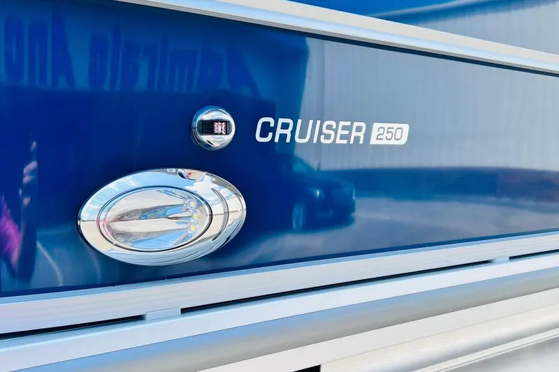 Slide: The Image of 2026 Harris Cruiser 250 boat exterior with sleek blue finish and chrome details. - 7