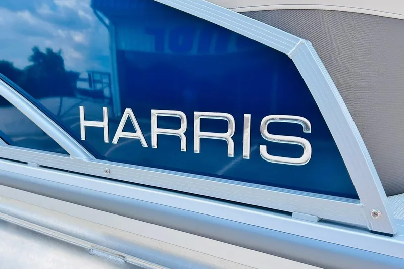 Slide: The Image of 2026 Harris Cruiser Sunliner 250 CW boat, blue panel with silver logo. - 8
