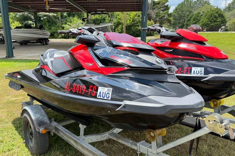 Slide: The Image of 2014 Sea-Doo RXT-X 260 jet skis on trailers, parked outdoors. - 14