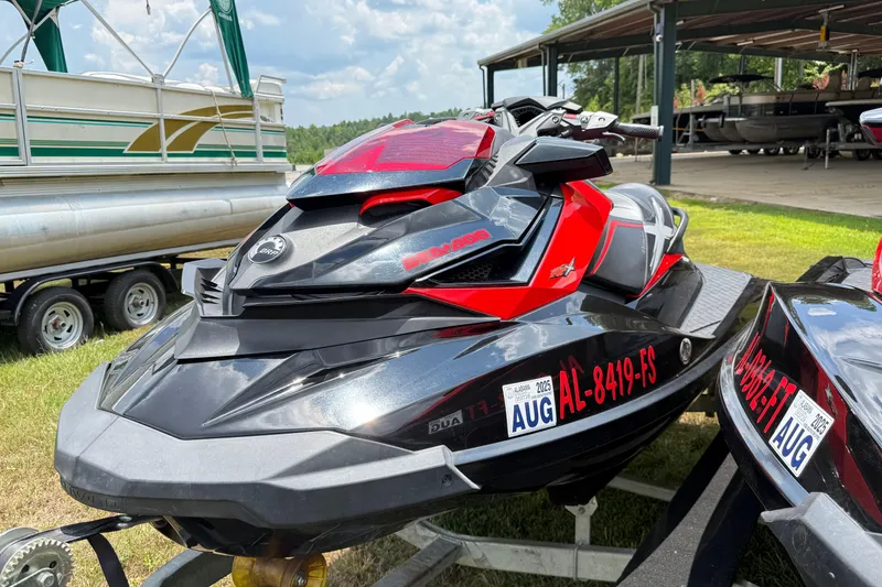 Slide: The Image of 2014 Sea-Doo RXT-X 260 jet ski in black and red, parked outdoors. - 15