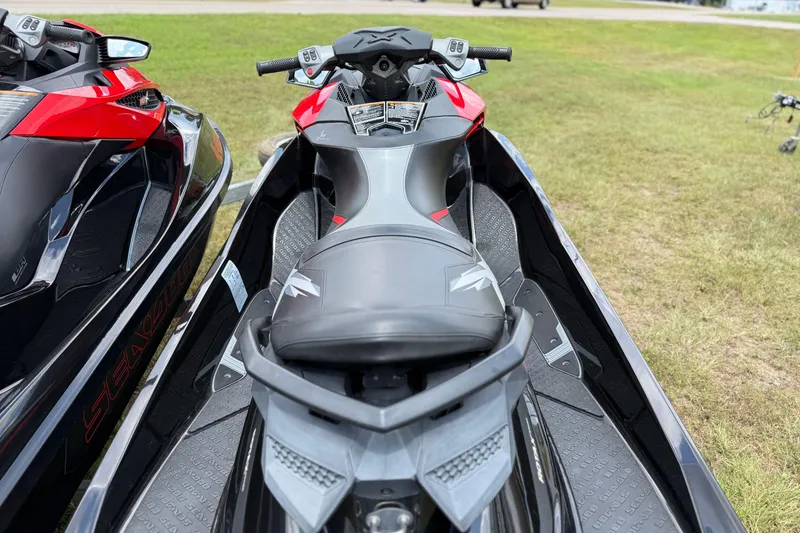 Slide: The Image of 2014 Sea-Doo RXT-X 260 jet ski, black and red, parked on grass. - 17