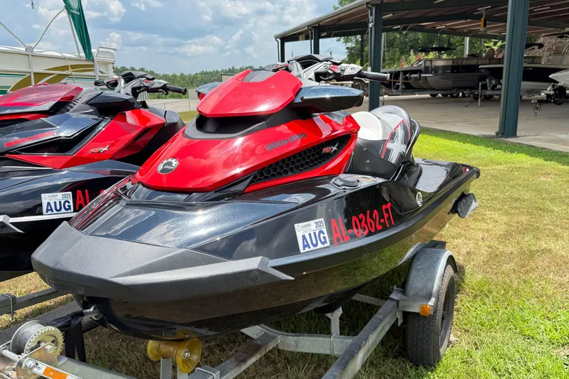Slide: The Image of 2014 Sea-Doo RXT-X 260 jet ski on trailer, red and black design, parked outdoors. - 2