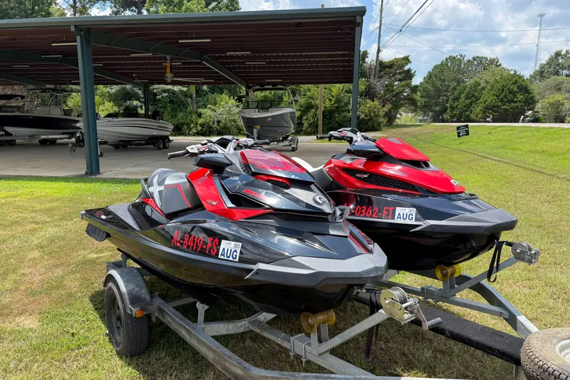 Slide: The Image of 2014 Sea-Doo RXT-X 260 jet skis on trailer, parked on grass near covered boat storage. - 6