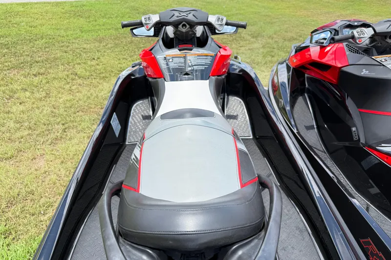 Slide: The Image of 2014 Sea-Doo RXT-X 260 jet ski with red and black design on grass. - 8