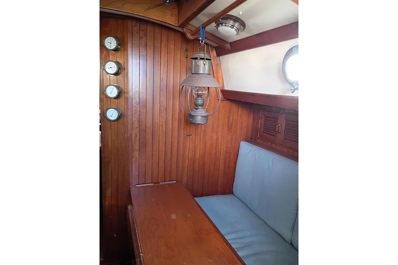 Slide: The Image of Interior of 1978 Baba Cutter sailboat with wooden paneling and vintage lantern. - 17
