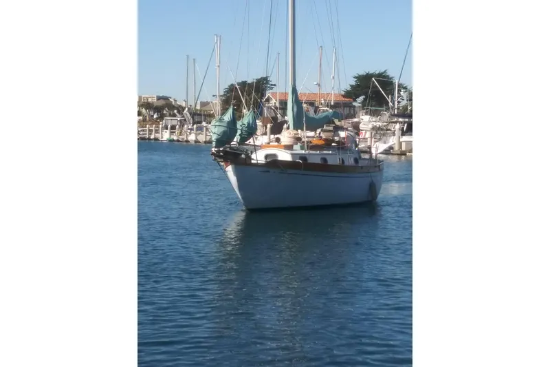 Slide: The Image of Vintage 1978 Baba Cutter sailboat docked in a sunny marina. - 9