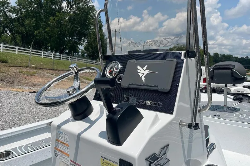 Slide: The Image of 2026 Xpress H20 BAY boat console with steering wheel and controls, outdoors. - 7