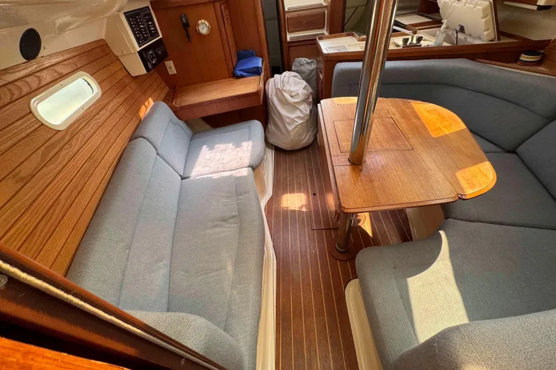 Slide: The Image of Cozy interior of a 1995 Hunter 336 sailboat with wooden table and cushioned seating. - 15
