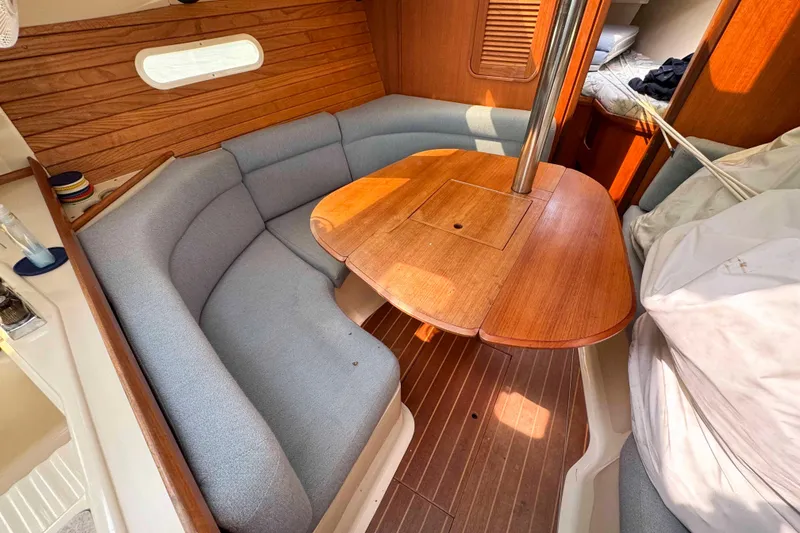 Slide: The Image of Interior of a 1995 Hunter 336 sailboat with a cozy dining area and wooden table. - 16