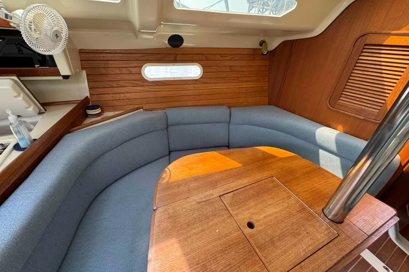 Slide: The Image of Cozy interior of a 1995 Hunter 336 sailboat with blue seating and wooden accents. - 17