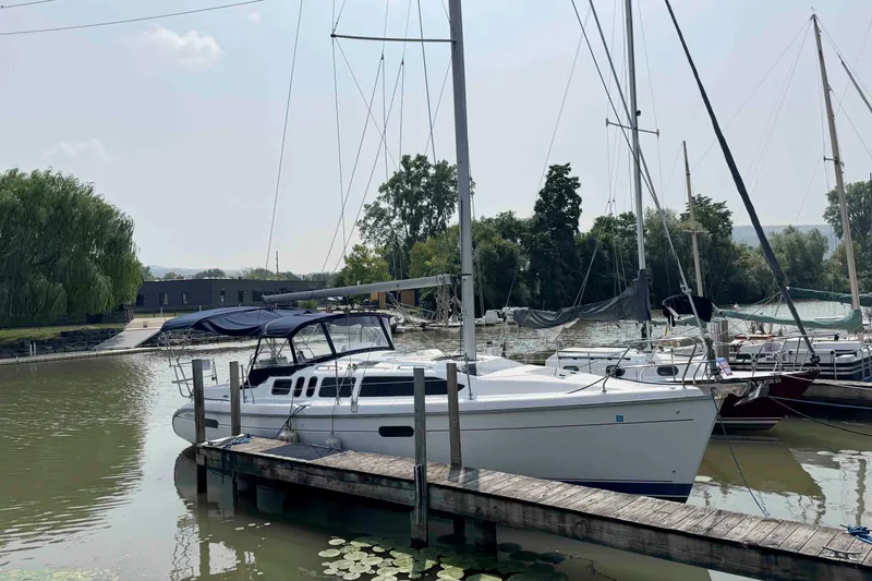 Slide: The Image of Sailboat docked at marina, Hunter 336 model, 1995, surrounded by calm water and greenery. - 2