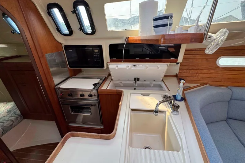 Slide: The Image of Interior of 1995 Hunter 336 sailboat kitchen with stove, sink, and seating area. - 22