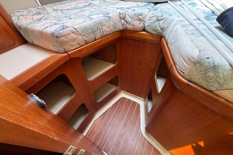 Slide: The Image of Interior of a 1995 Hunter 336 sailboat with wooden cabinetry and cushioned bed. - 23