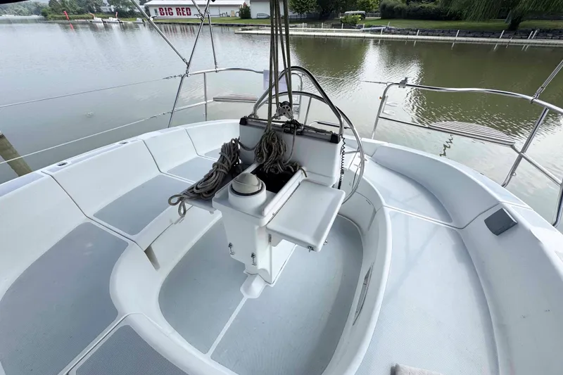 Slide: The Image of Cockpit of 1995 Hunter 336 sailboat with ropes and steering wheel, docked by calm water. - 5