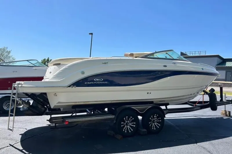 Slide: The Image of 2005 Chaparral 256 SSi boat on trailer, parked outdoors under clear blue sky. - 4