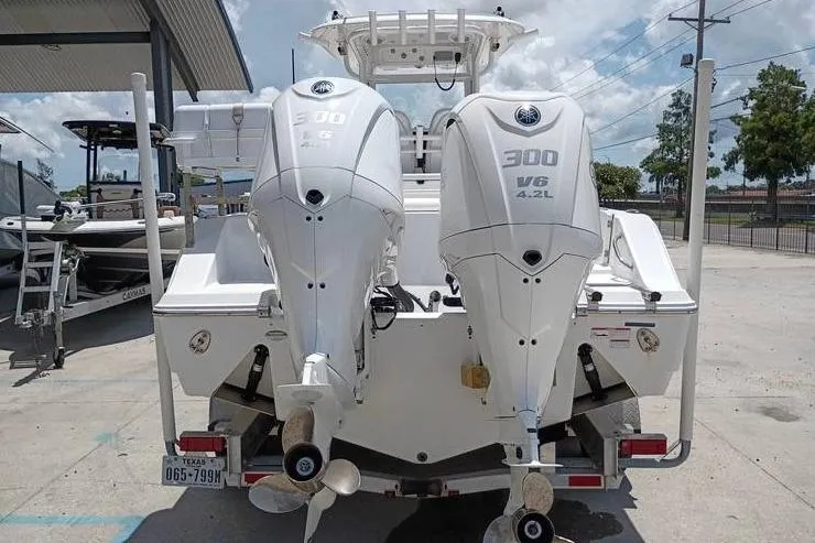 Slide: The Image of 2021 Sportsman Open 282 Center Console boat displayed outdoors under cloudy sky. - 13