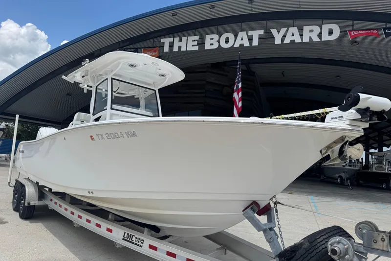 Slide: The Image of 2021 Sportsman Open 282 Center Console boat on trailer under cloudy sky. - 2